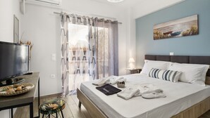 Une chambre d’hôtel comprenant un lit, une télévision, un bureau avec un panier et une chaise.