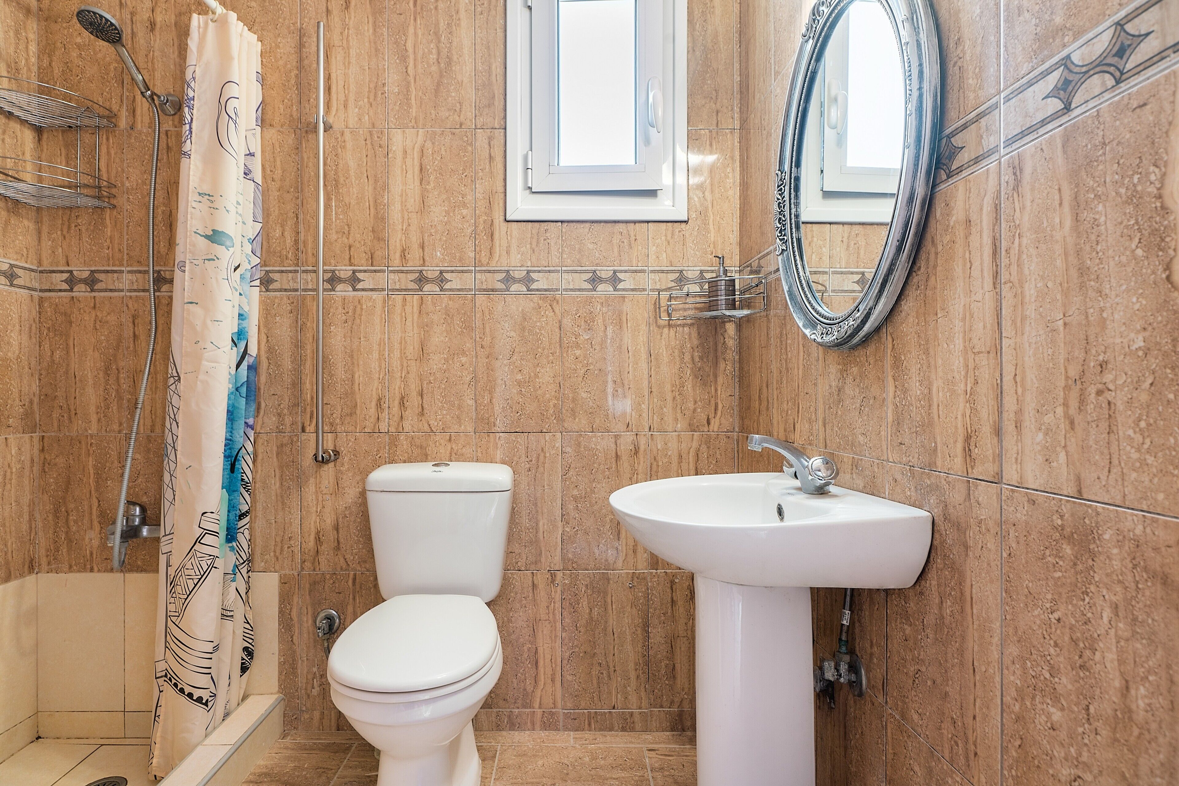 Un baño con ducha, inodoro, lavamanos y espejo.