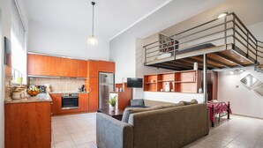 A modern apartment with a kitchen, living area, and a loft bedroom with a balcony. - Apartment 'Rafaela's House' with Shared Pool, Wi-Fi and Air Conditioning (Koskinou)