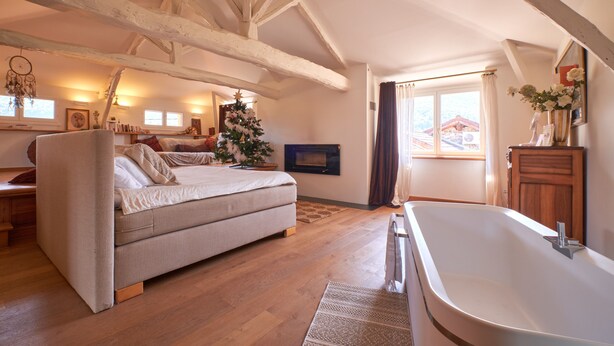 A bedroom with a bed, a wooden floor, a fireplace, and a large window. - Vacation Home with Mountain View in the Vercors National Park (IZERON)