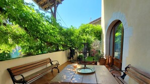 An outdoor patio with wooden benches, a table, and potted plants. - Vacation Home with Mountain View in the Vercors National Park (IZERON)