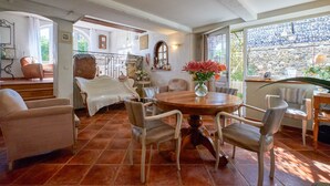 A dining area with a round table, chairs, and a vase of flowers. - Vacation Home with Mountain View in the Vercors National Park (IZERON)