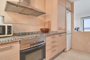 A modern kitchen with a built-in oven, microwave, and refrigerator.