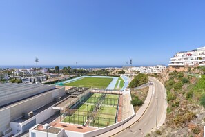 A stadium with a running track, seating areas, and a green field.