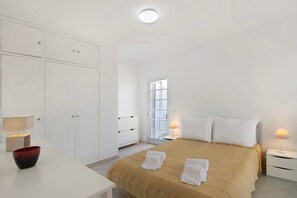 A bedroom with a bed, bedside tables, a window, and a wardrobe.