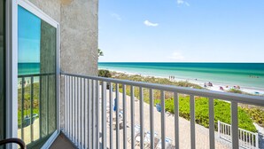 A balcony with a view of a beach and ocean.