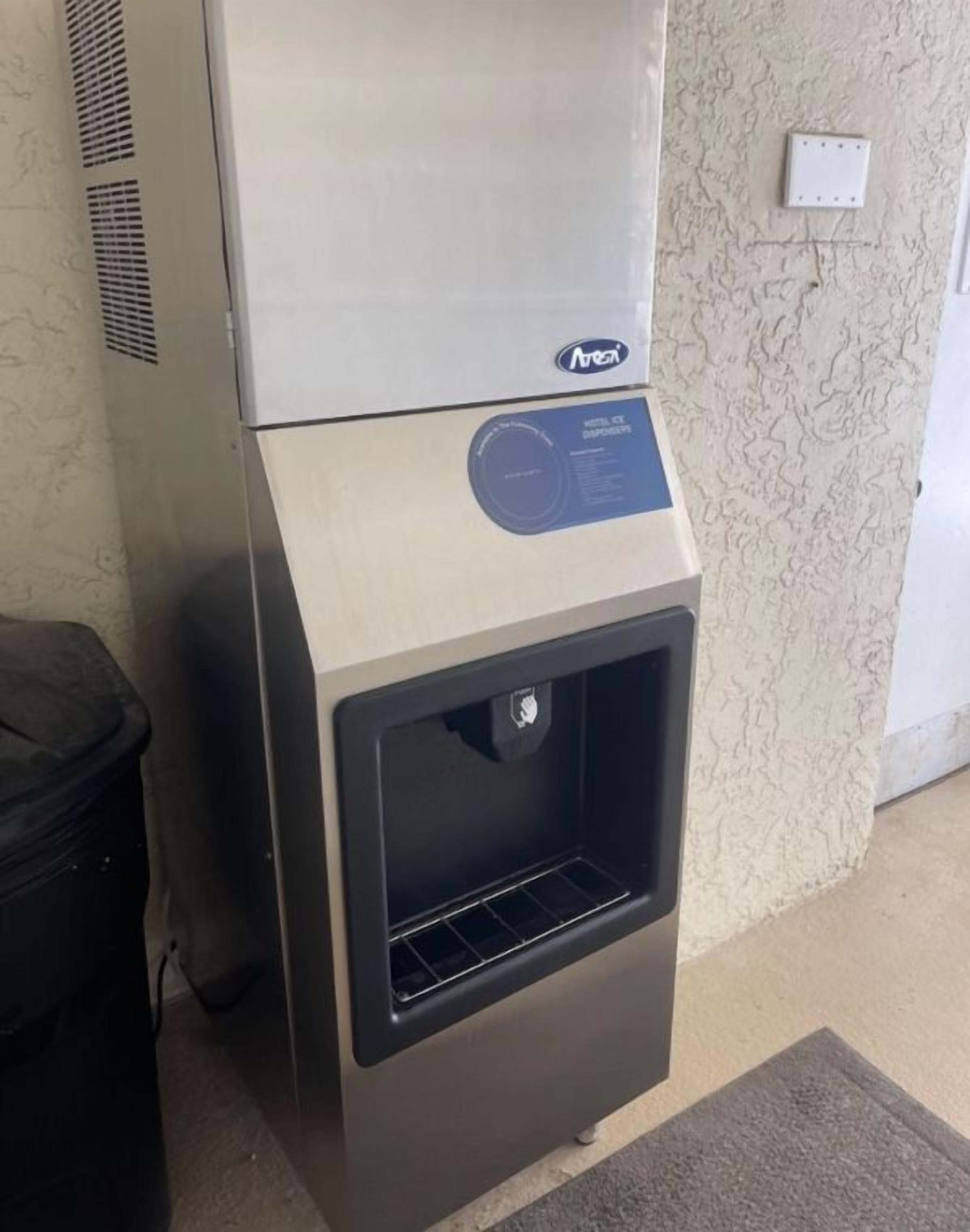 Een compacte, moderne hotelkamer met een kitchenette en een koffieapparaat.