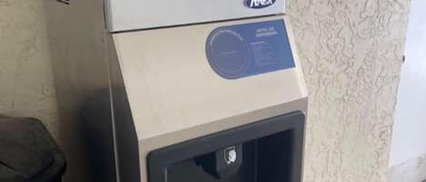 Een compacte, moderne hotelkamer met een kitchenette en een koffieapparaat.