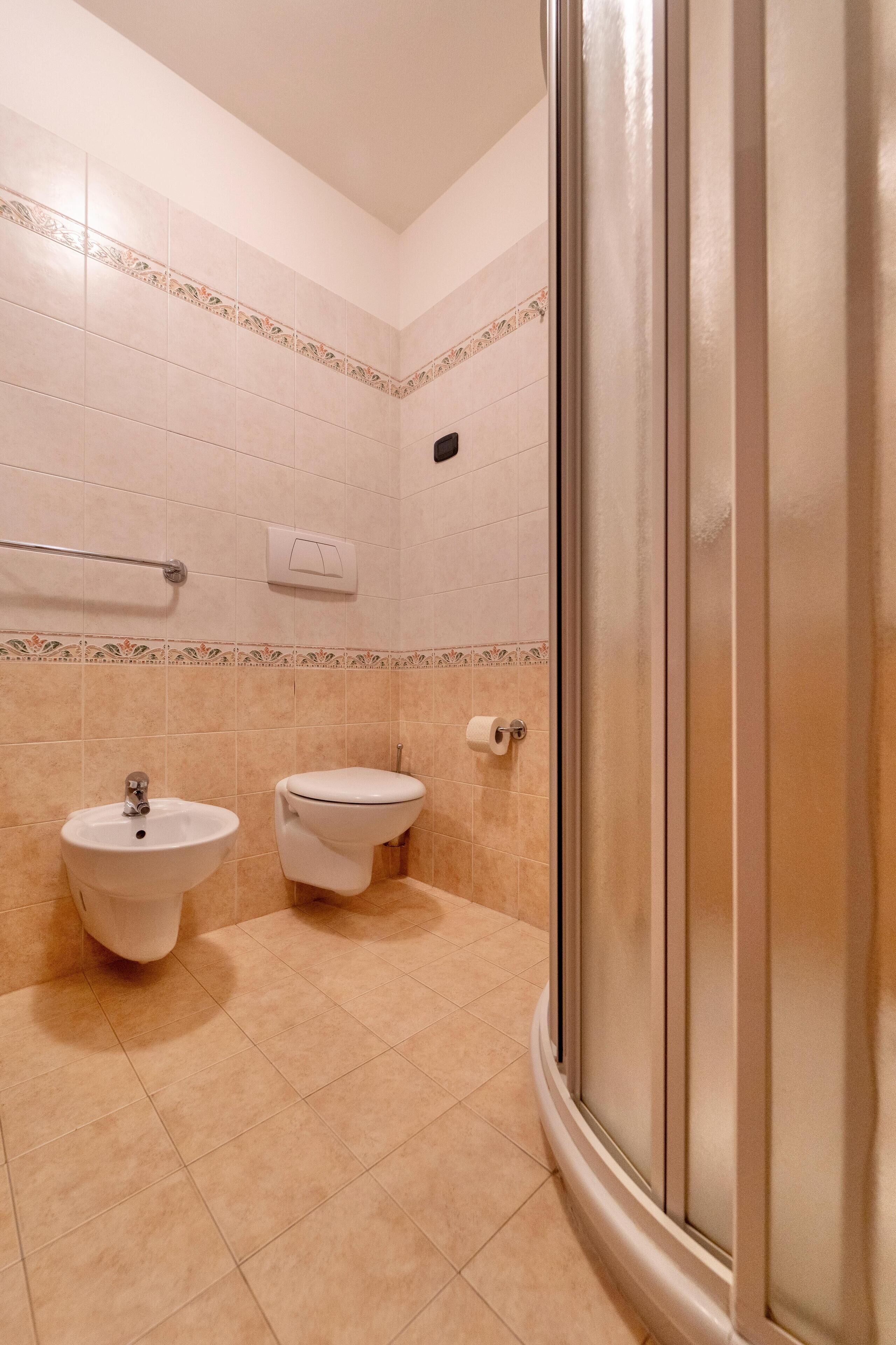 A bathroom with a sink, toilet, and shower.