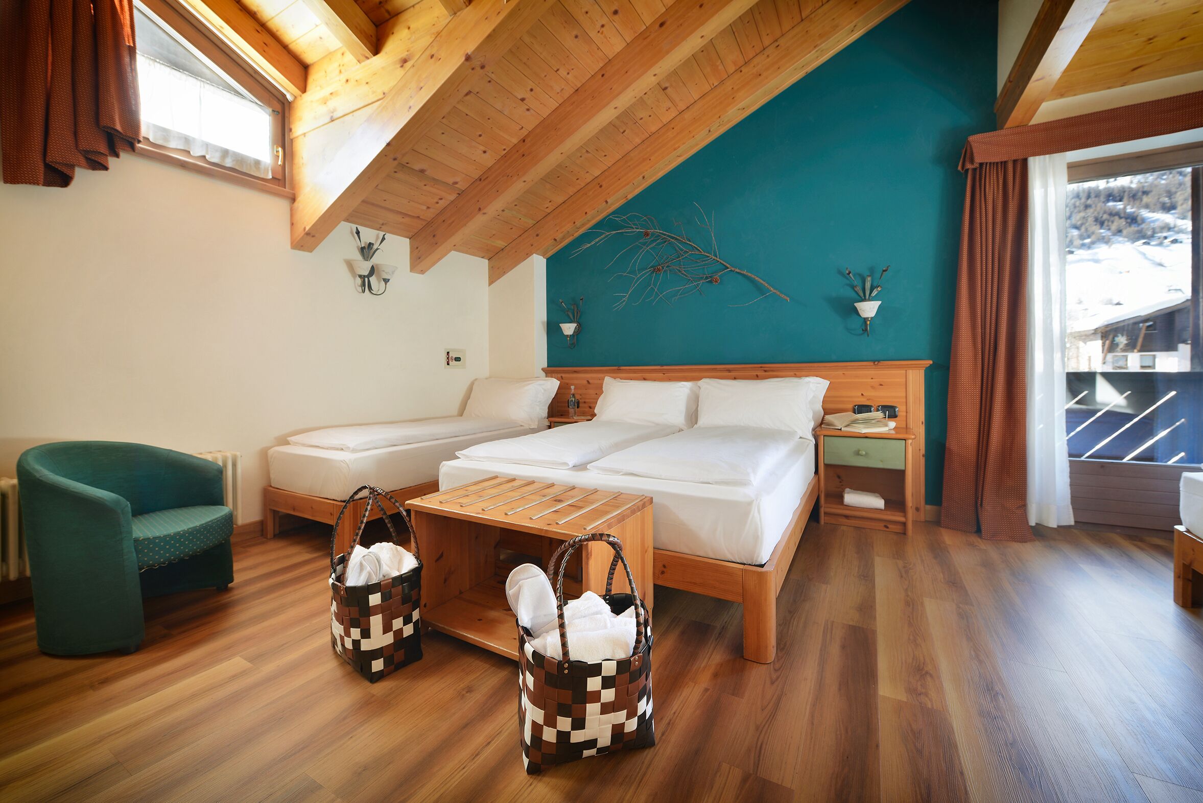 Ein gemütliches Zimmer mit einem Bett, einer Couch, einem Holztisch und zwei gewebten Taschen.