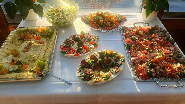 A table with various food platters, including cheese, fruits, and meats, arranged on a white tablecloth. - Business Hotel Siebeneichen GmbH (Meissen)