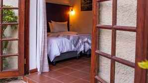 Um quarto com uma cama, uma mesa de cabeceira e uma luminária fixada na parede.