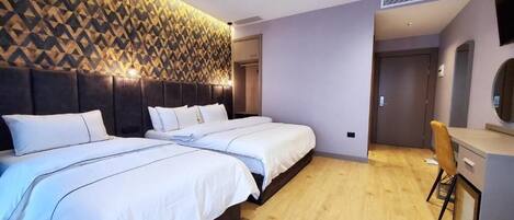 Une chambre d’hôtel moderne avec deux lits, un plancher en bois, un mur décoré de motifs et un petit bureau avec une chaise.