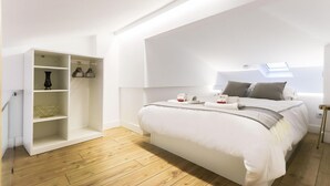 Un dormitorio moderno con cama estilo loft, estanterías empotradas y tragaluz.