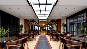 A hotel lobby with a central corridor, leather chairs, and tables. - ASPEN HOTEL ÇANAKKALE (Çanakkale)