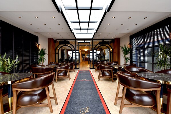 A hotel lobby with a central corridor, leather chairs, and tables. - ASPEN HOTEL ÇANAKKALE (Çanakkale)