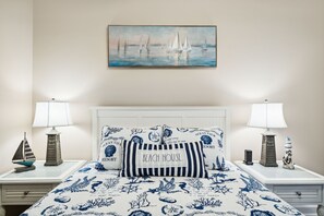 Ein Schlafzimmer mit einem Bett, zwei Nachttischen, einem Gemälde und Dekorationselementen.