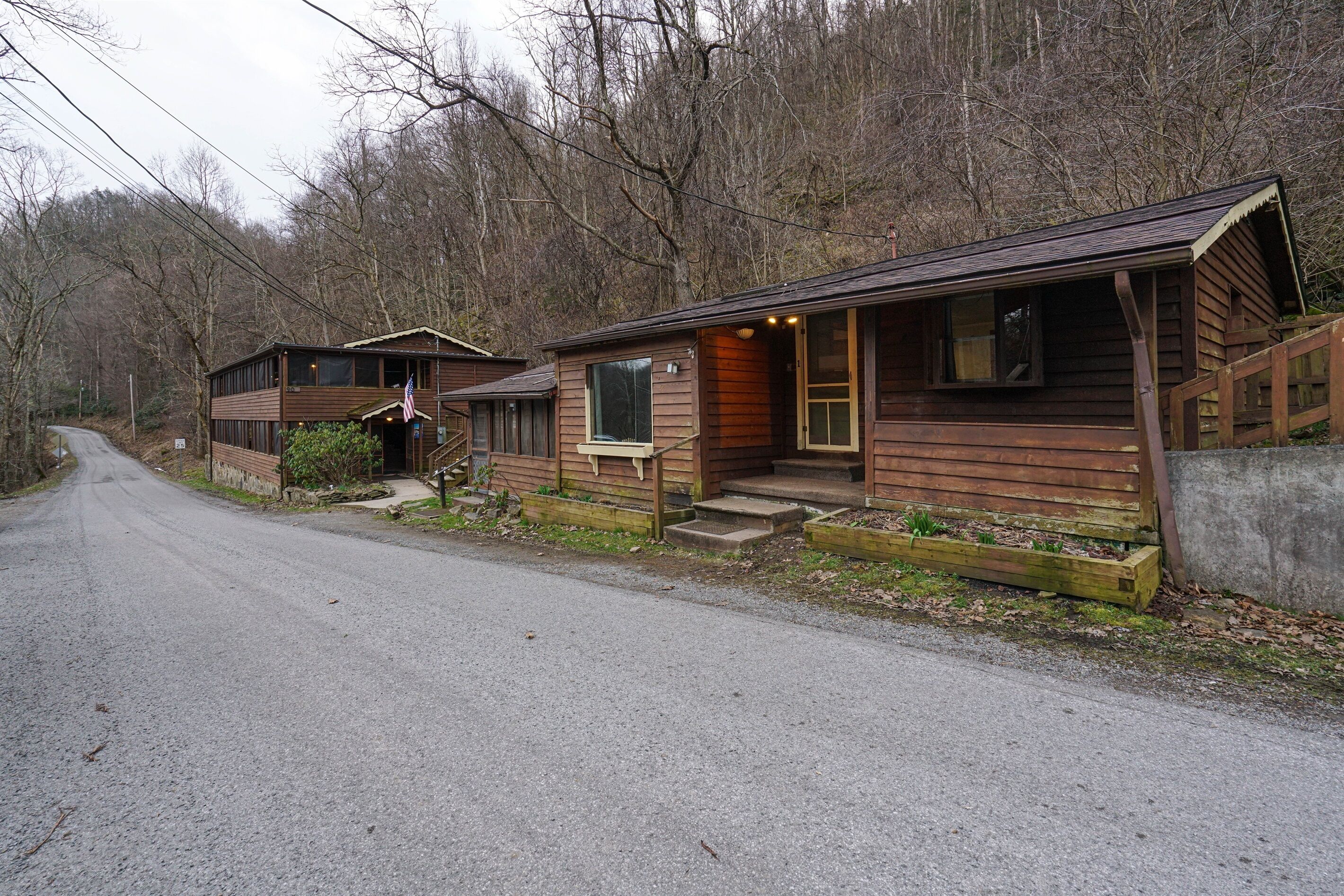 A rustic cabin with a porch, a front door, and a small window.