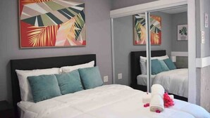 A hotel room with a bed, a large mirror, and abstract art on the wall.