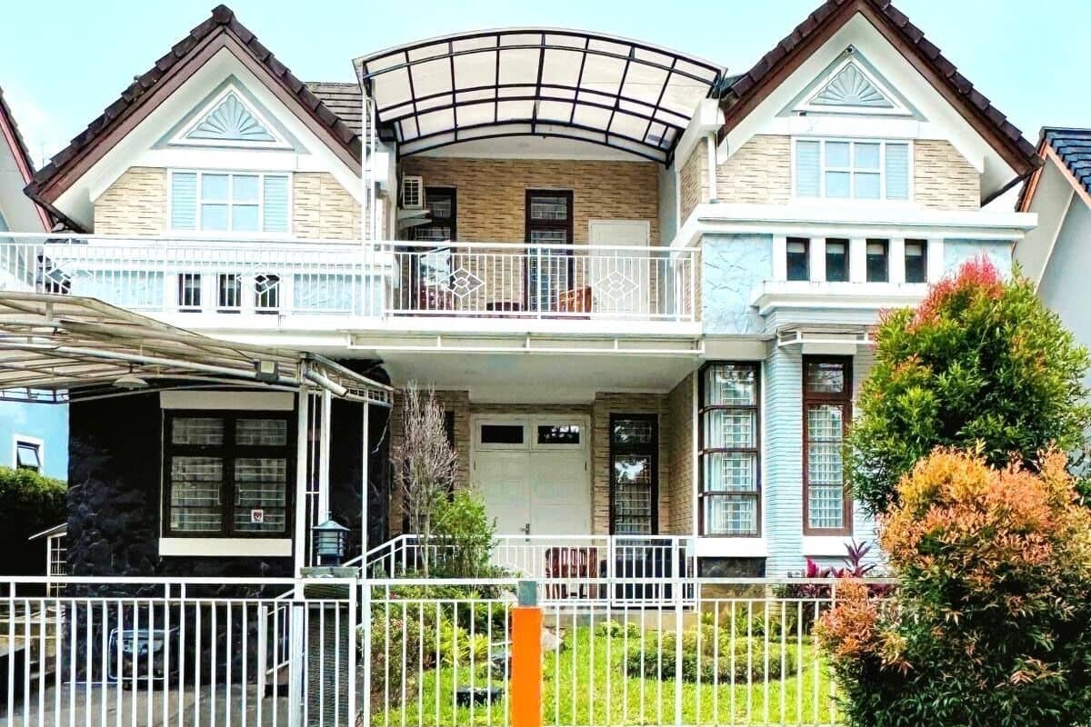 Una casa de dos pisos con balcón, garaje y un césped bien cuidado.