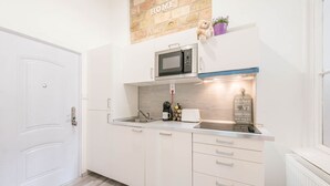 Cocina moderna con armarios blancos, microondas, cafetera y un cartel que dice 'cocina donde se hacen buenas comidas'.
