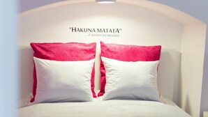 A bed with two pillows, one white and one pink, and a wall with the text "HAKUNA MATATA" and a subtitle. - happy home Budapest PINK   Central located apartment with 80  039 s pinball machine (Budapest)