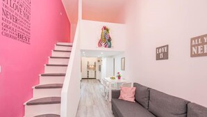 A modern interior with a staircase, a grey sofa, and motivational wall art. - happy home Budapest PINK   Central located apartment with 80  039 s pinball machine (Budapest)