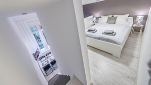 A modern hotel room with a large bed, a bedside table, and a view of the outside. - happy home Budapest DIAMOND Central located apartment with 80 039 s pinball machine (Budapest)