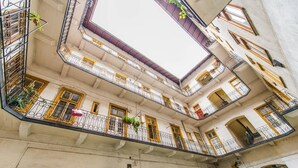 Um edifício de vários andares com varandas, arcadas e um pátio central.