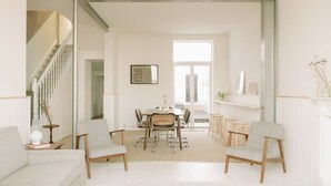 Amplia sala de estar con comedor, una escalera y un ventanal que proporciona luz natural.