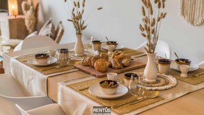 Una mesa de comedor dispuesta con diferentes platos, incluyendo tazones, vasos y una tabla de madera con pasteles.