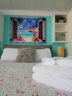 Relax in comfort with a plush bed, vibrant artwork, and natural textures.