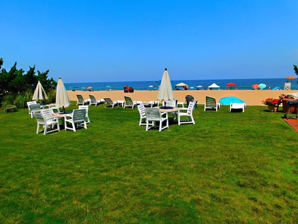 Relax in style with comfortable lounge chairs and tables on the lush lawn, overlooking the sandy beach.