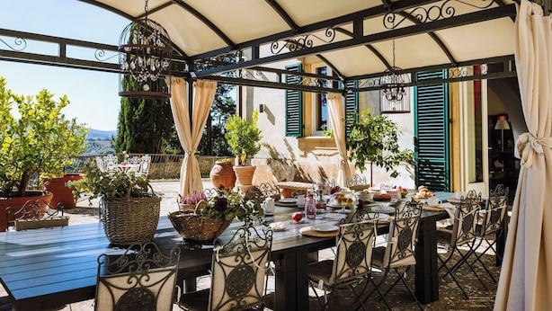 An outdoor patio with a covered seating area, potted plants, and a table set for dining. - Wonderful private villa with WIFI, A/C, private pool, patio and panoramic view, close to Siena (Poggibonsi)