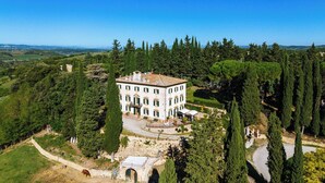 A large, white building with multiple windows and a central courtyard, surrounded by dense greenery and trees. - Wonderful private villa with WIFI, A/C, private pool, patio and panoramic view, close to Siena (Poggibonsi)