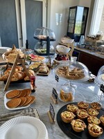 Una mesa de buffet con diversos alimentos, como pasteles, frutas y bebidas.