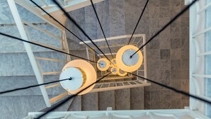 A modern interior with a spiral staircase and a ceiling with circular light fixtures.