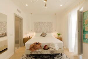 Una habitación de hotel con una cama grande, una mesita de noche, un escritorio y una silla.