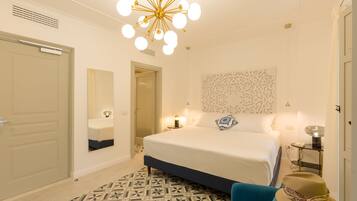 Une chambre à coucher moderne avec un grand lit, un panneau mural décoratif, un lustre original et un tapis à motifs.