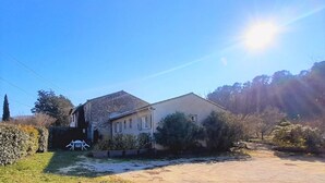 Ein zweistöckiges Haus mit Steinverkleidung und einem großen Vorgarten.