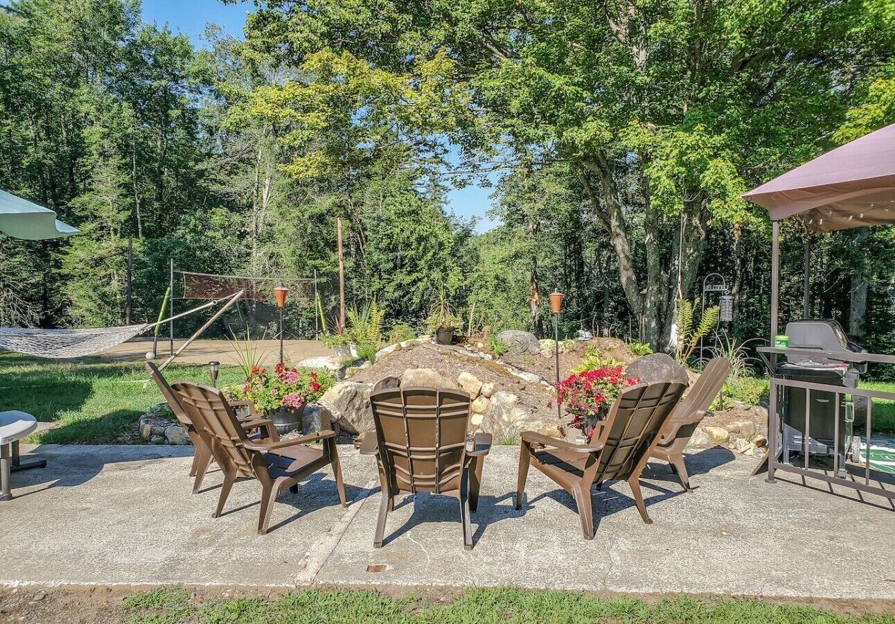 An outdoor patio area with seating and a grill.