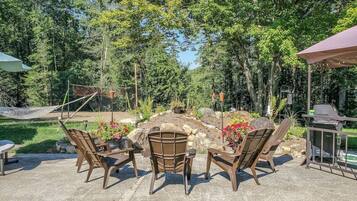An outdoor patio area with seating and a grill.