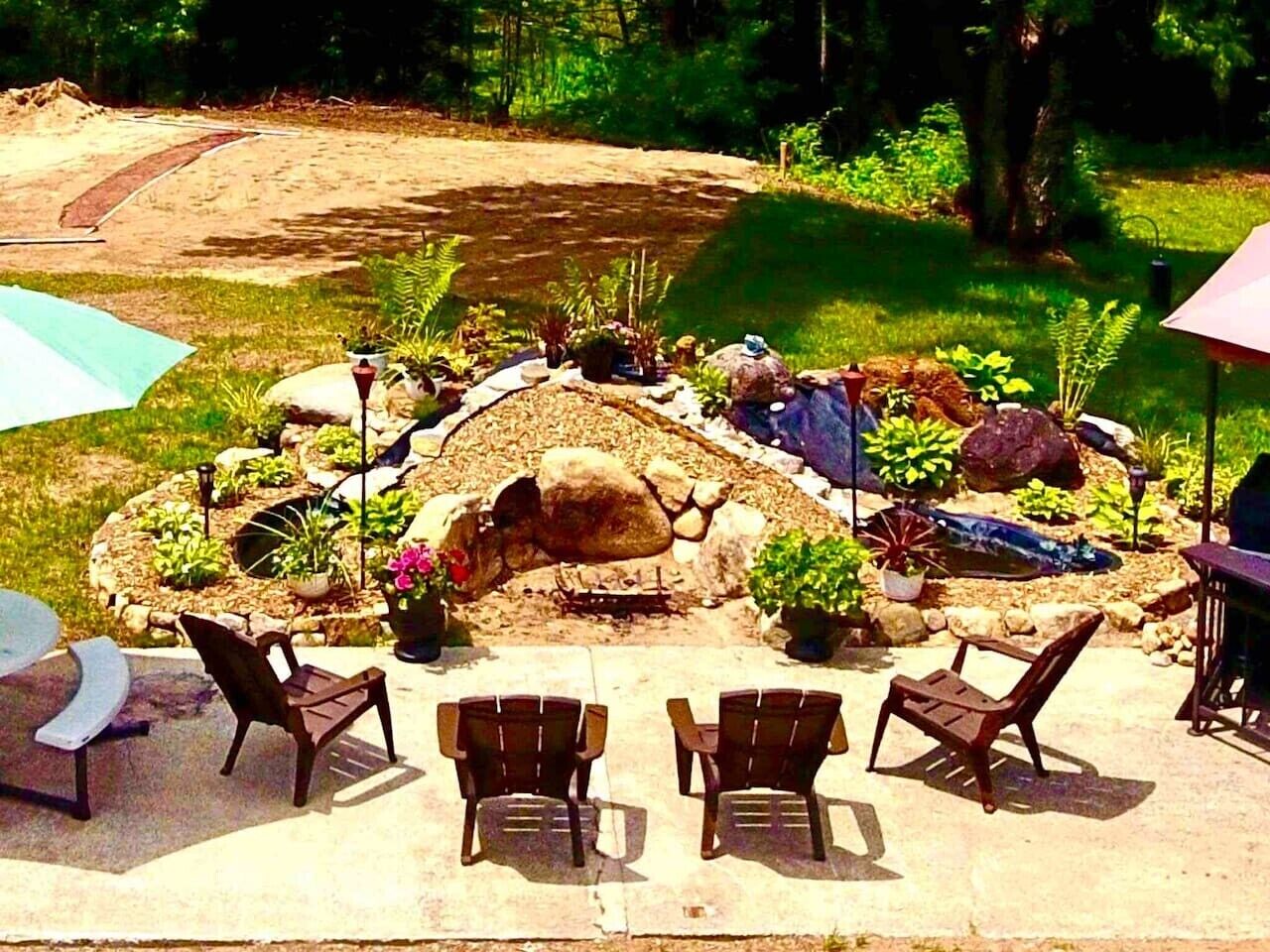 An outdoor patio with stone seating and a small pond.