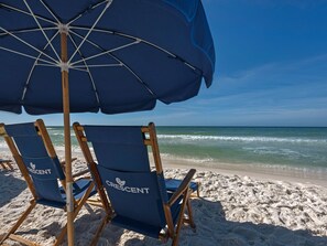 Relax in comfort under a spacious umbrella, surrounded by the soothing sound of waves.