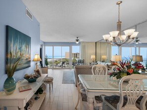Enjoy ocean views from the high ceiling living area with a dining table, sofa, and chandelier.