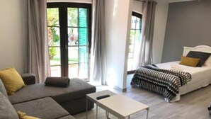 A modern bedroom with a bed, a sofa, and a small table. - Old Village (Loulé)