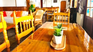 Una mesa de comedor de madera con una planta en maceta, rodeada de sillas amarillas.