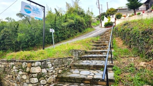 Una escalera de piedra que sube con un letrero que indica el Hotel Yalla Choreft.