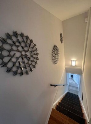 Stunning staircase with handrail and decorative wall art, leading to an upper level.