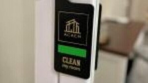 Una porta amb un senyal negre i verd que indica que l'habitació està neta.